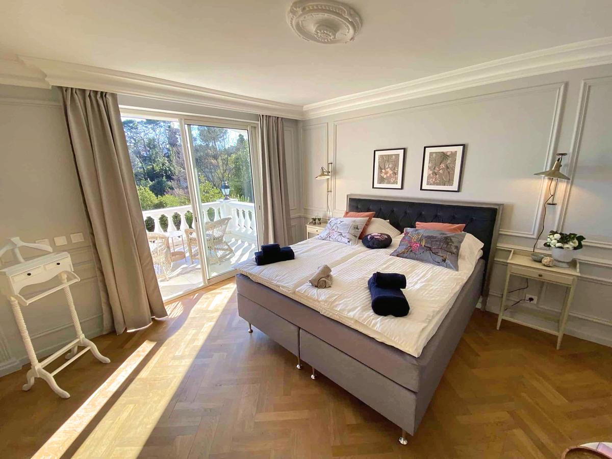 Master bedroom med en-suite badrum och balkong